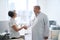 Doctor greets an elderly patient with handshake in medical office