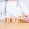 Doctor hand flipping 2023 to 2024 block. Happy New Year for Medical, Health care, Insurance and Wellness concepts