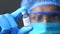 Doctor hand in gloves holding coronavirus vaccine, close up