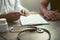 Doctor hand holding pen and talking to the patient about medication and treatment