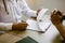 Doctor hand holding pen writing patient history list on note pad and talking to the patient about medication and treatment