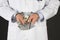 Doctor in handcuffs with bribe on black background. Corrupted medicine