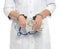 Doctor in handcuffs with bribe and stethoscope on background, closeup. Corrupted medicine