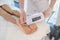 Doctor hands with apparatus above feet of lying patient