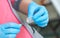 Doctor hands in blue gloves hold syringe. Preparation for blood test. Medical woman holding injector in arm.