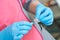 Doctor hands in blue gloves hold syringe. Preparation for blood test. Medical woman holding injector in arm.