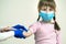 Doctor hands making disinfection preparing hand of child girl for injection wearing blue protective medical mask ill with