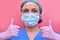 The doctor hands, in a pink medical glove, gives a thumbs - up gesture of approval. A nurse in a blue uniform makes a gesture that