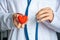 A doctor or healthcare professional holds heart shape in one hand and stethoscope in other. Concept photo for diagnosing and deter