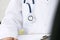 Doctor with his stethoscope in his breast pocket, closeup view or the instrument, on white.