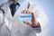 Doctor holding card with word PREBIOTICS on light blue background, closeup