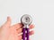 Doctor holding in hand round detail of purple stethoscope. Close-up. Medicine