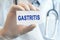 Doctor holding a paper card with text GASTRITIS, medical concept