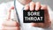 Doctor holding a paper card with text sore throat, medical concept