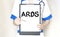 Doctor holding a paper plate with text ARDS, medical concept