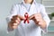 Doctor holding red awareness ribbon indoors, closeup. World AIDS disease day