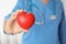 Doctor holding red heart in hand, closeup.