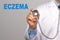 Doctor holding a stethoscope with ECZEMA word on gray background. Skin diseases concept