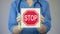 Doctor holding stop sign, warning about unhealthy lifestyle, harmful habits