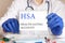 Doctor holding a tablet with text: HSA. HSA - HEALTH SAVING ACCOUNT, medical concept