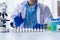 Doctor holding test tube with blue liquid, laboratory analysis for microscopic