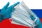 Doctor holds face masks in hands blue gloves on background national flag of Russia. Concept quarantine, hygiene