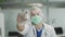 The doctor holds in his hand and demonstrates the latest developed vaccine against covid-19. The interior of the