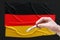 A doctor holds a test tube with a positive blood test for coronavirus in front of the German flag. Covid-19 epidemic, infection,
