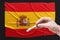 A doctor holds a test tube with a positive blood test for coronavirus in front of the Spanish flag. Covid-19 epidemic, infection,