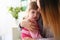 Doctor hugging scared crying little baby girl visiting her office