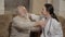 Doctor hugs old man at the doctor`s reception