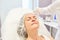 Doctor injects hyaluronic acid dermal filler during a facelift