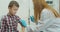 A doctor injects a vaccine into the boy shoulder. The concept of vaccination of children and the prevention of