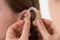 Doctor Inserting Hearing Aid In The Ear Of A Girl