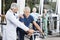 Doctor Instructing Senior Man On Exercise Bike At Fitness Center