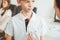 Doctor and kid patient are in the clinic. Physician in white coat examining a serious young boy with a stethoscope