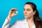 A doctor or lab technician holds a polio vaccine on a blue background. Vaccination and prevention poliomyelitis. Infantile