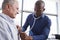 Doctor Listening To Chest Of Senior Male Patient During Medical Exam In Office