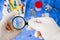 Doctor looking a vaccine ampule through a magnifier in a laboratory