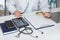 Doctor looks with a magnifying glass at a document in his office