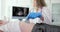 Doctor makes ultrasound of abdominal cavity of girl using scanner in clinic
