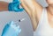 The doctor making intramuscular injection with syringe of botulinum toxin in the armpit against hyperhidrosis