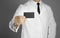 Doctor. A man in a white coat, white shirt and black tie holds a black business card. Without a face