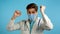 Doctor with mask funny dancing, success and luck at work. Young handsome doc man in professional medical white coat is