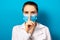 The doctor in the mask shows a sign of silence finger at the mouth. Medical mystery in medicine and health care, medical error and