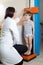 Doctor Measuring Height of Little Boy on Traditional Medical Scale