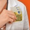 Doctor in medical clothes with euro money, orange background. A nurse is counting in her hands the money of a European bank,