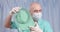 A doctor in a medical mask and rubber gloves shows a large enema.