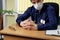 Doctor in a medical mask sits at a table and intently listens