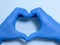 Doctor or nurse with blue latex gloves creating a heart with copy space for health protection love